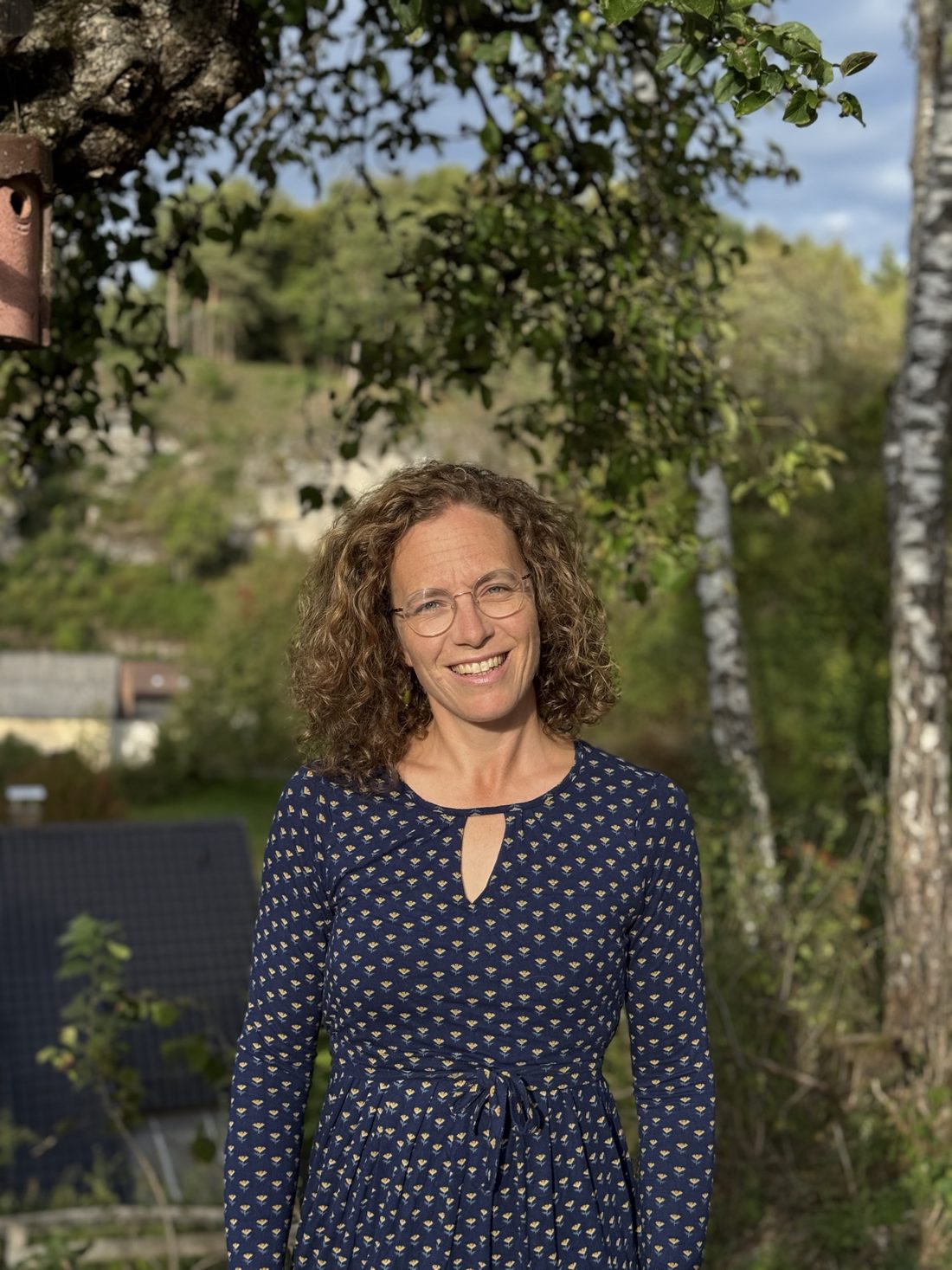 Amelie Göbel, Hebamme, lächelnd zwischen Birken